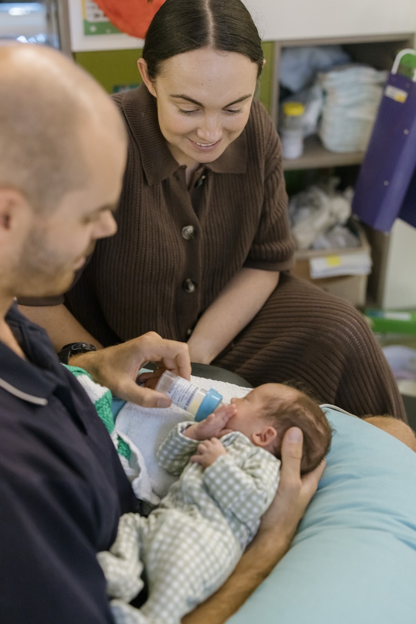 A parent feeding their baby in care